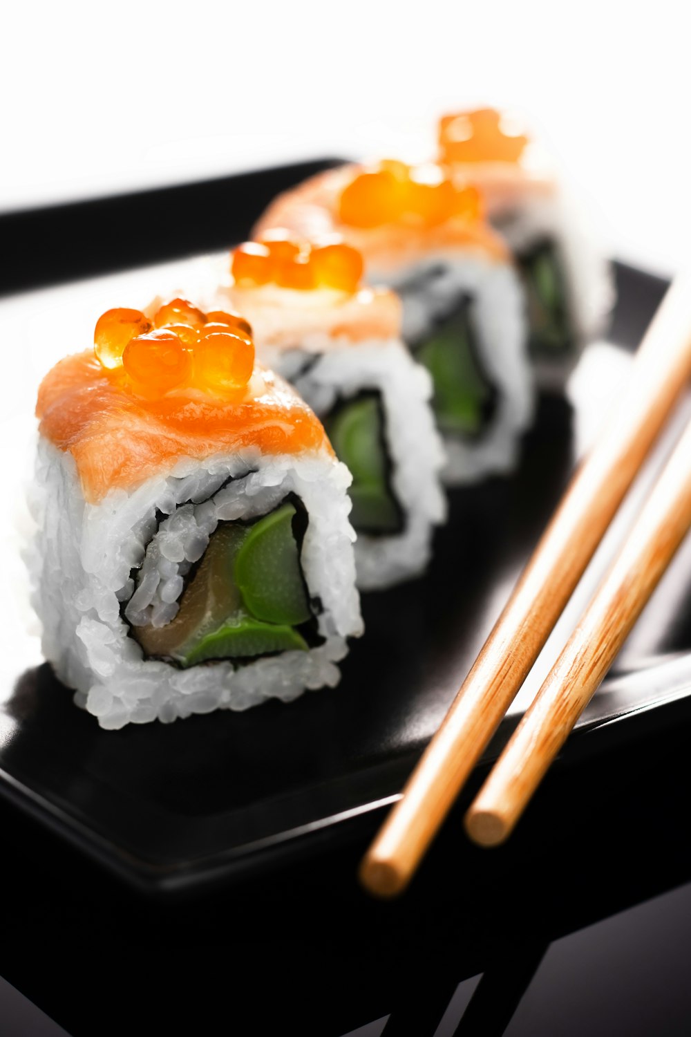 Salmon-and-ikura maki on a black plate