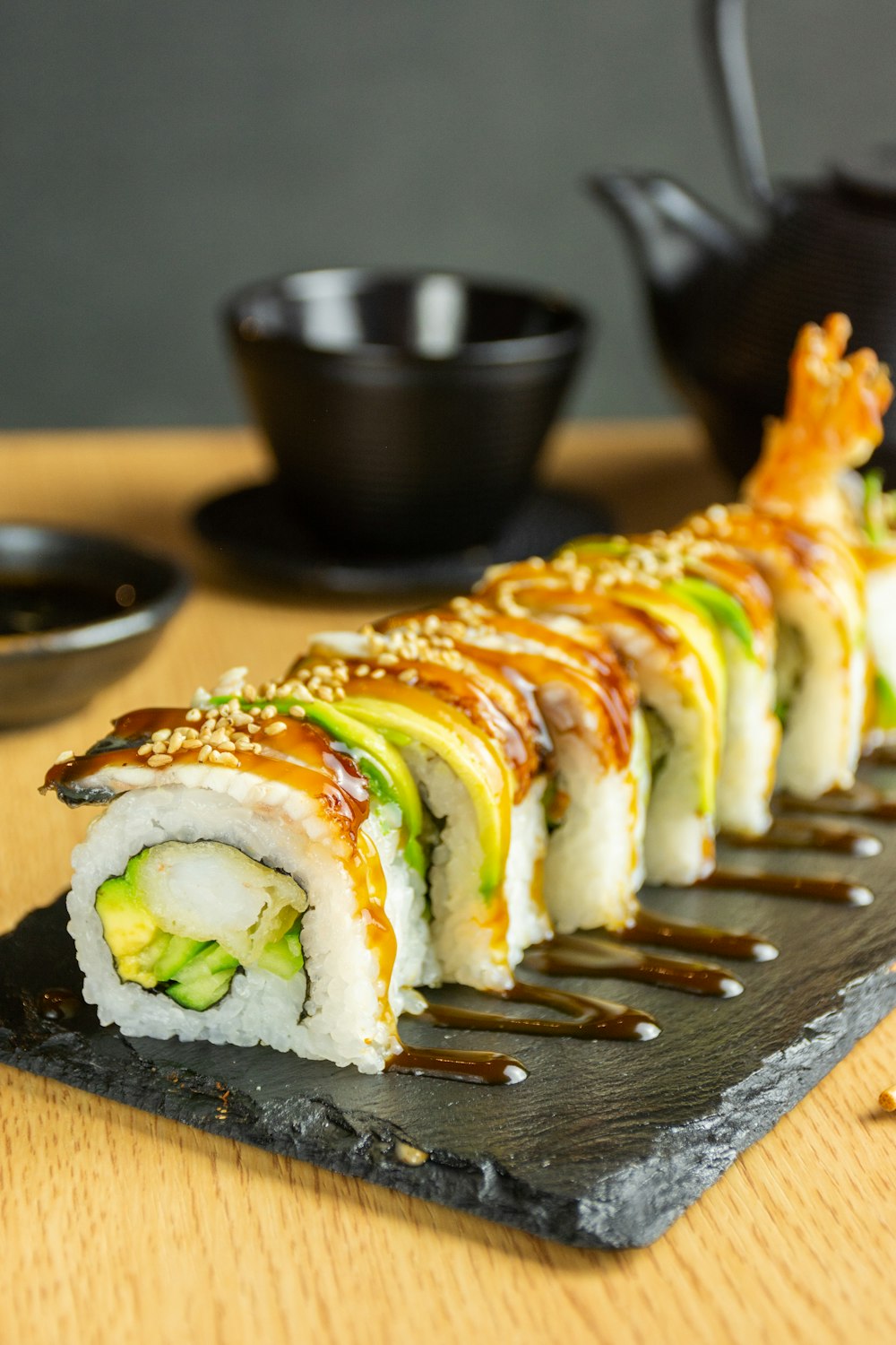 Dragon roll garnished with avocado and sesame